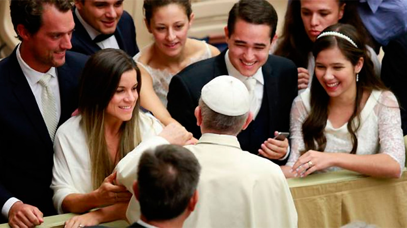 El Papa Francisco saluda a un grupo de recién casados.