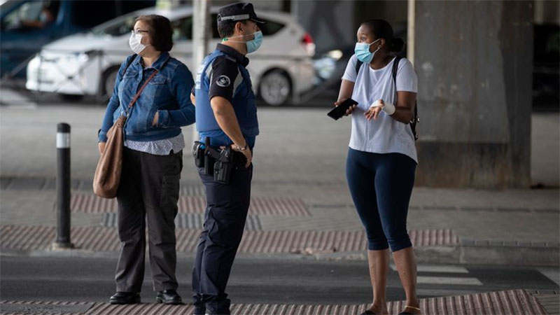 Policía habla con una mujer en un punto de control, en Madrid