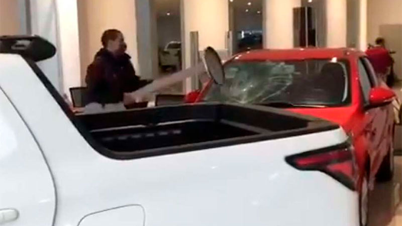 Enfurecido, un hombre destroza un auto en concesionaria.