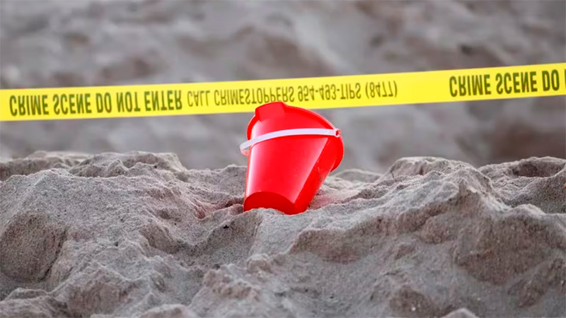 Un balde cerca de una cinta policial en la playa, en Lauderdale-by-the-Sea.