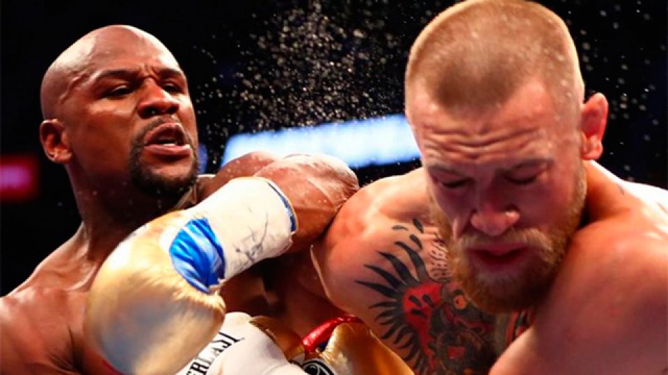 Mayweather conectando un certero golpe a su rival McGregor.