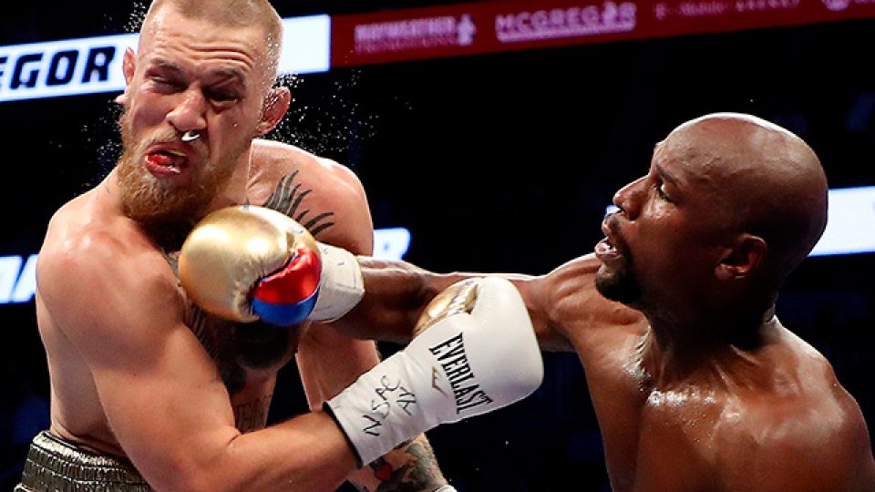 Mayweather conectando un certero golpe a su rival McGregor.