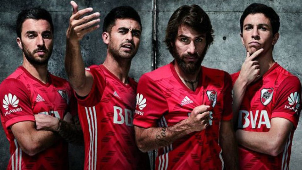 Las figuras de la Banda posan con la nueva camiseta alternativa roja.