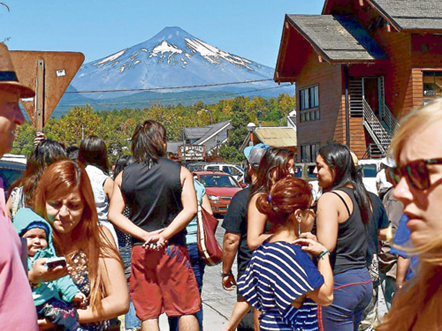 Turistas recorrían ayer las calles de Pucón, expectantes sobre el volcán.