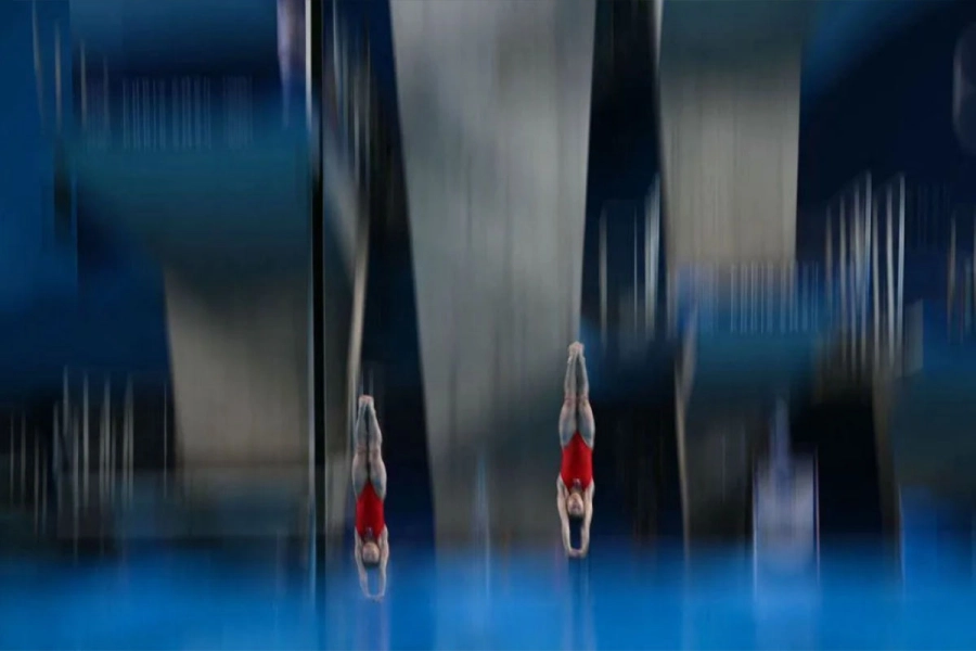 Jo Jin Mi y Kim Mi Rae de Corea del Norte hacen un salto desde la plataforma de 3 metros.