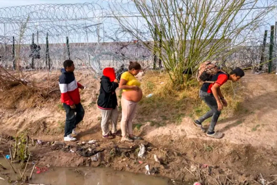 Una mujer embarazada y otros migrantes caminan en la orilla del r&iacute;o Bravo tras cruzar la frontera entre EE.UU y M&eacute;xico en El Paso, Texas. (Foto: Getty Images)