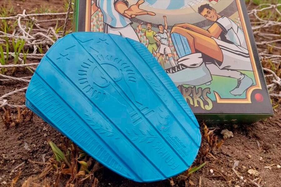 Las canilleras fabricadas con tapitas de plástico.