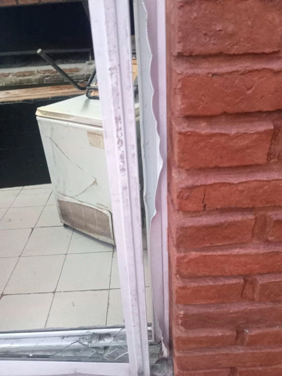 El vidrio roto de la ventana por donde ingresaron los delincuentes.