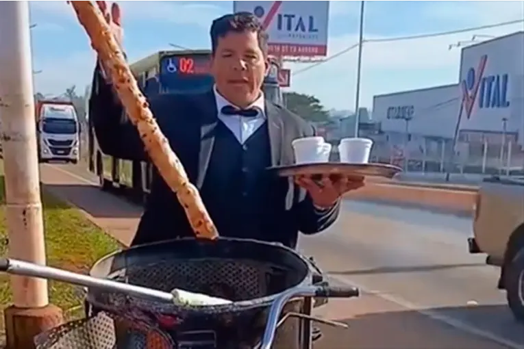 Vende café a la vera de Ruta 12, vestido con traje, moño y una bandeja en la mano: video