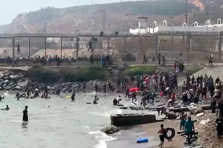 Migrantes llegan a la costa espa&ntilde;ola desde el mar y superan una valla de l&iacute;mite fronterizo.-