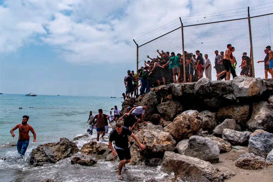 Migrantes llegan a la costa espa&ntilde;ola desde el mar y superan una valla de l&iacute;mite fronterizo.-