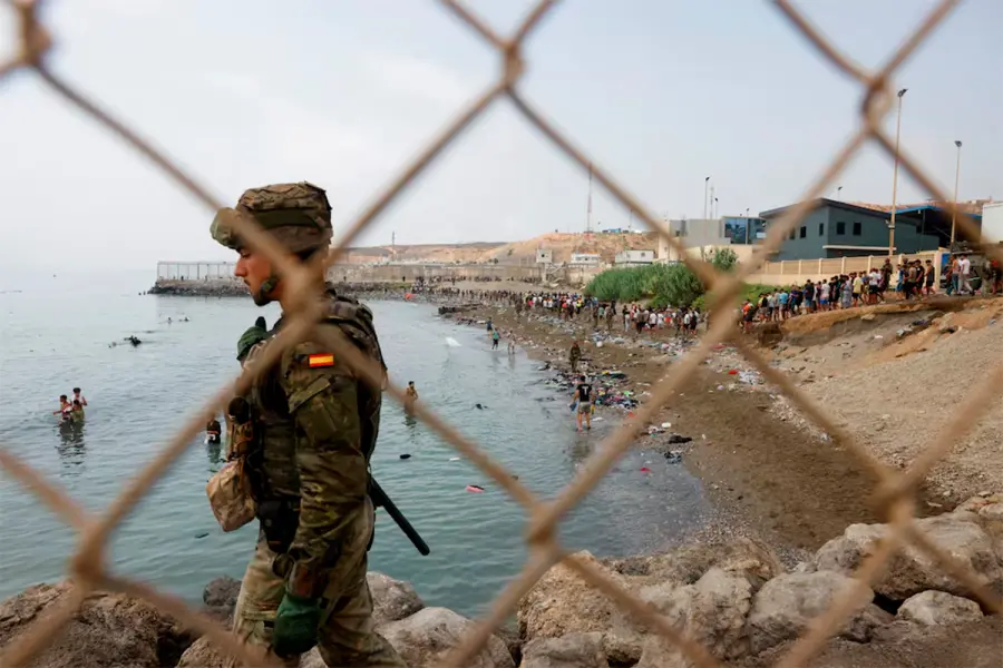 Migrantes llegan a la costa espa&ntilde;ola desde el mar y superan una valla de l&iacute;mite fronterizo.-