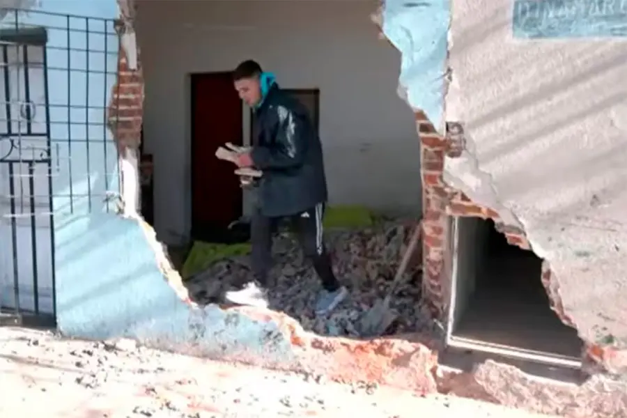 Un joven saca sus pertenencias de lo que qued&oacute; de la habitaci&oacute;n (fuente La Naci&oacute;n)